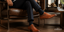 Gentleman wearing premium leather dress shoes with tailored trousers walking through a luxury hotel courtyard